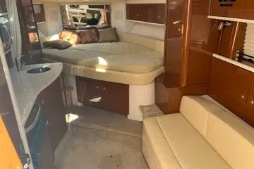 Slide: The Image of Interior of 2008 Sea Ray Sundancer 310, featuring cozy seating and a compact kitchenette. - 9