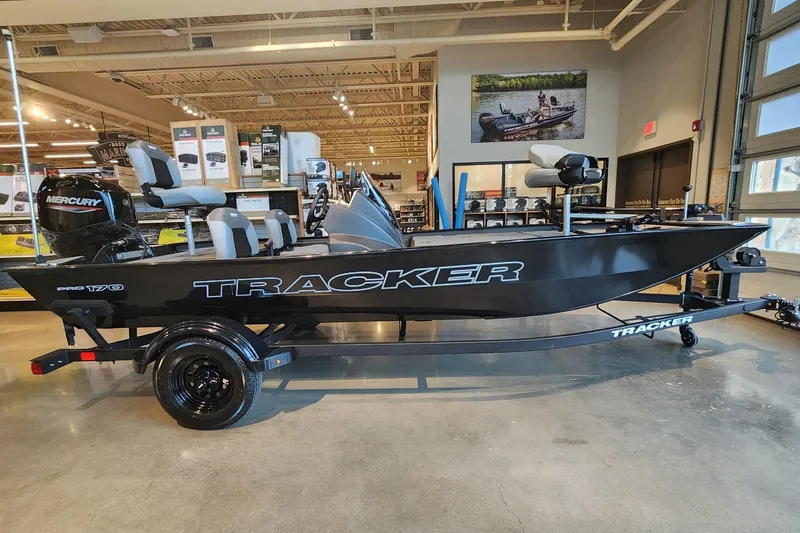 The Image of 2027 Tracker Pro 170 boat displayed indoors with Mercury engine and trailer. - 0