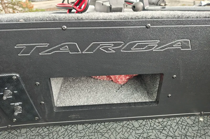 Slide: The Image of 2027 Tracker Targa V-18 Combo boat dashboard with controls and storage compartment. - 37