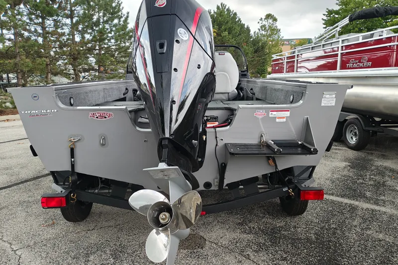 Slide: The Image of 2027 Tracker Targa V-18 Combo boat with powerful outboard motor, parked outdoors. - 42