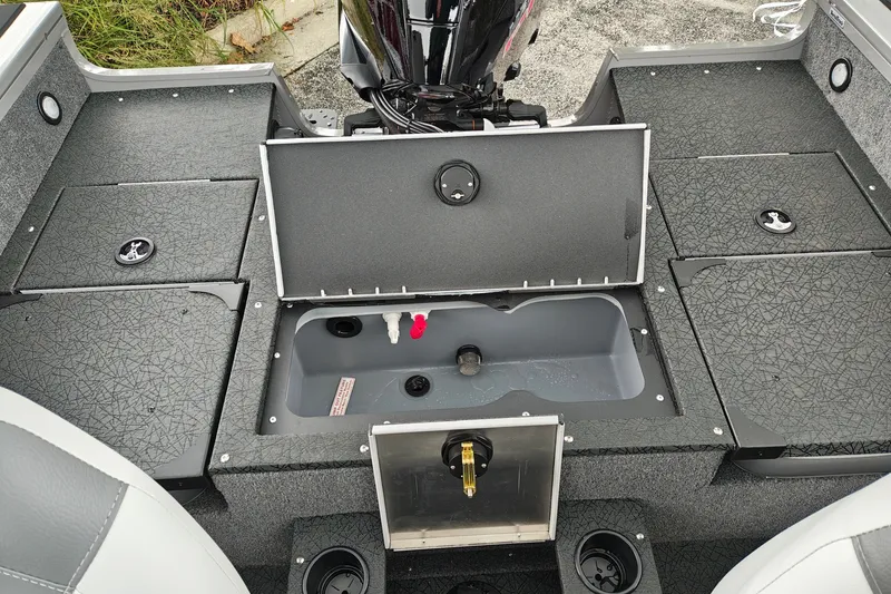 Slide: The Image of 2027 Tracker Targa V-18 Combo boat interior with storage compartments and motor. - 17