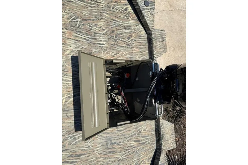 Slide: The Image of 2027 Tracker Grizzly 1860 CC boat interior with open hatch and visible wiring. - 14