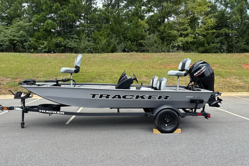 The Image of 2027 Tracker Pro 170 boat on trailer, parked outdoors with green trees in background. - 0