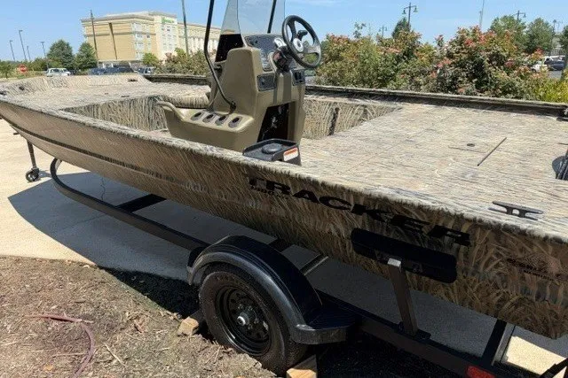 The Image of 2027 Tracker Grizzly 1860 CC boat on trailer, camo design, parked outdoors. - 0
