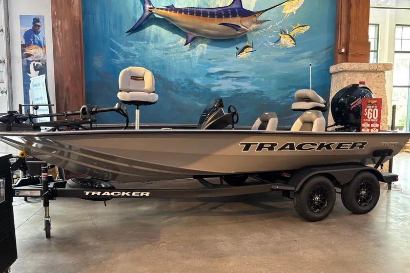 The Image of 2027 Tracker Pro Team 195 boat displayed indoors with marine-themed mural background. - 0