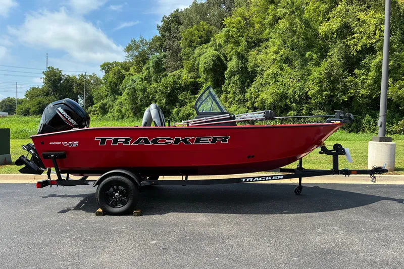 The Image of 2027 Tracker Pro Guide V-16 WT boat on trailer, vibrant red, parked outdoors. - 0