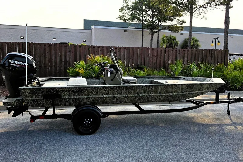 The Image of 2027 Tracker Grizzly 1860 CC boat on trailer, camo design, parked outdoors. - 0