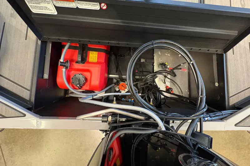 Slide: The Image of An open storage compartment with a red fuel tank and cables inside. - 14