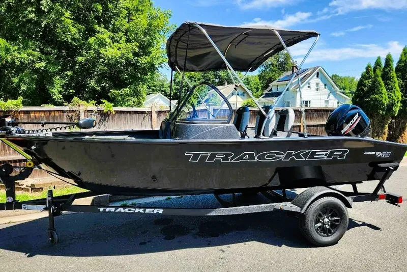 The Image of 2027 Tracker Pro Guide V-16 WT boat on trailer, parked outdoors. - 0