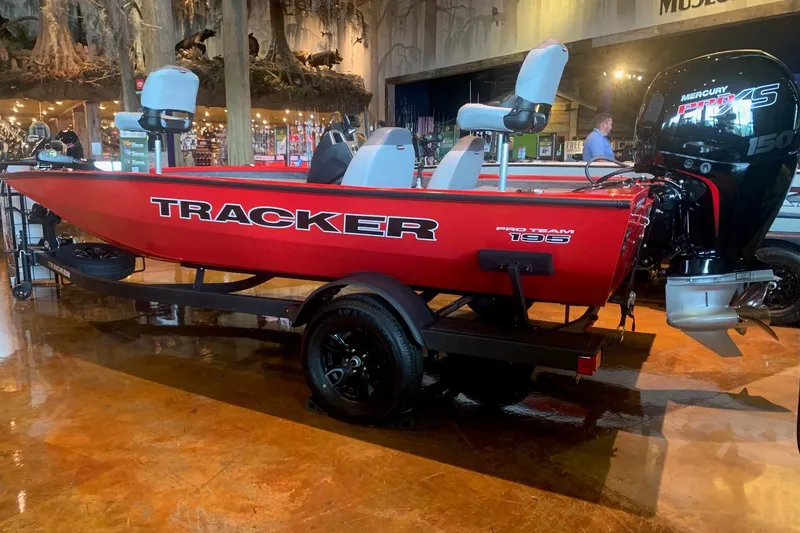 The Image of Red 2027 Tracker Pro Team 195 boat with Mercury engine displayed indoors. - 0