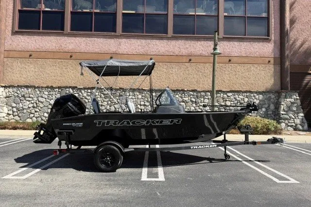 The Image of 2027 Tracker Pro Guide V-16 WT boat parked in a lot, side view. - 0