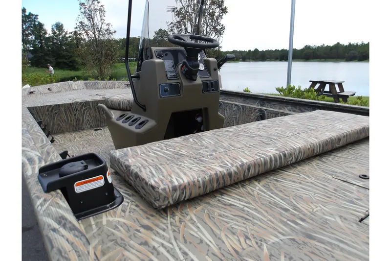 Slide: The Image of 2027 Tracker Grizzly 1860 CC boat with camouflage interior by a serene lake. - 15