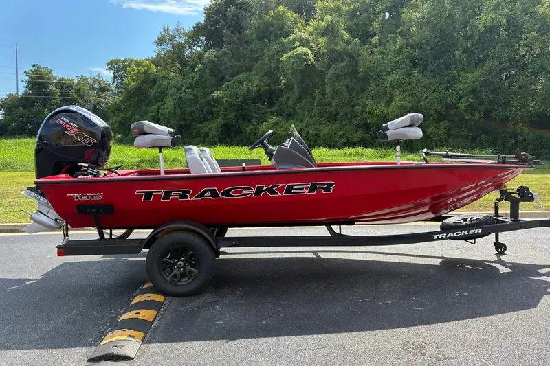 The Image of 2027 Tracker Pro Team 195 boat on trailer, vibrant red, parked outdoors. - 0