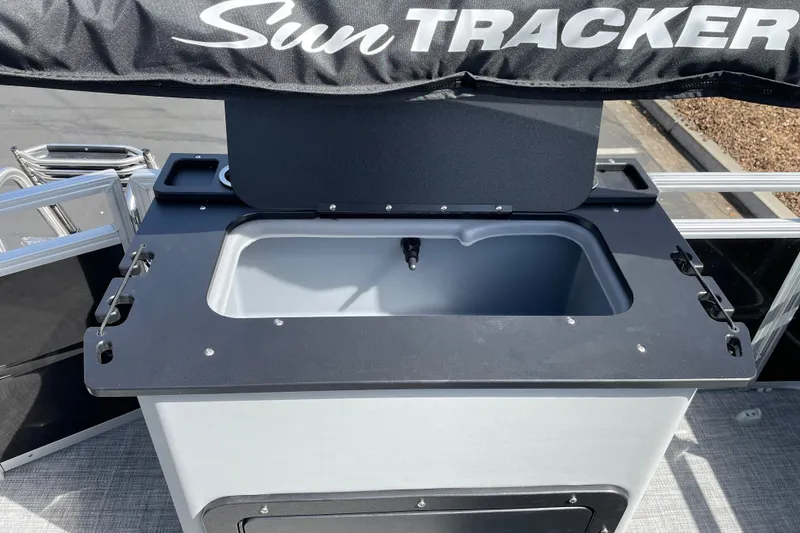 Slide: The Image of Sun Tracker SportFish 22 DLX 2027 boat with open storage compartment and sleek design. - 14