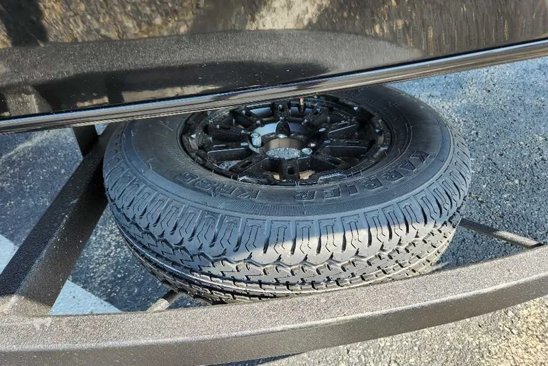 Slide: The Image of Spare tire on a 2027 Tracker Pro Team 195 trailer, parked on asphalt. - 41