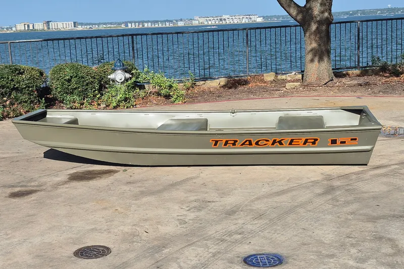 The Image of 2027 Tracker Grizzly 12 Jon boat on concrete near waterfront. - 0