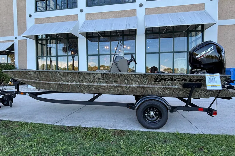 The Image of 2027 Tracker Grizzly 1860 CC boat on trailer, displayed outdoors near a building. - 0