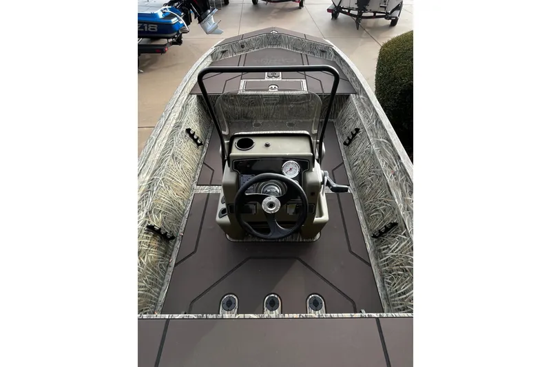 Slide: The Image of 2027 Tracker Grizzly 1860 CC boat interior with camouflage design and steering console. - 65
