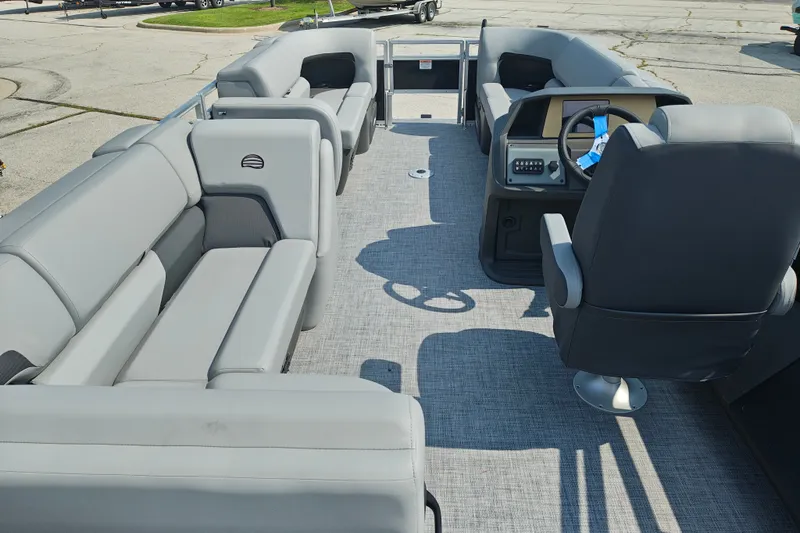 Slide: The Image of 2027 Sun Tracker SportFish 22 DLX pontoon boat interior with gray seating and helm. - 28