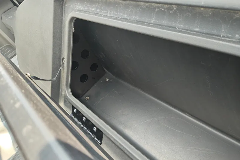 Slide: The Image of Storage compartment in 2027 Sun Tracker SportFish 22 DLX boat, featuring multiple ventilation holes. - 19
