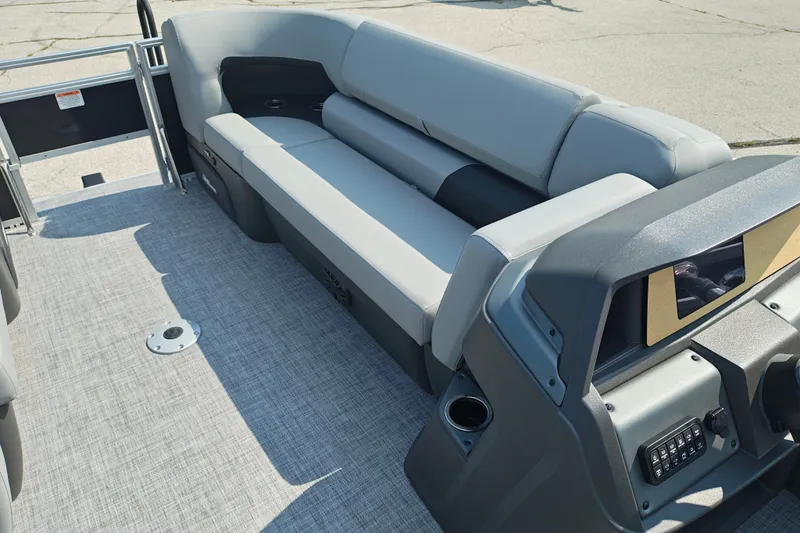 Slide: The Image of 2027 Sun Tracker SportFish 22 DLX pontoon boat interior with gray seating and modern dashboard. - 30