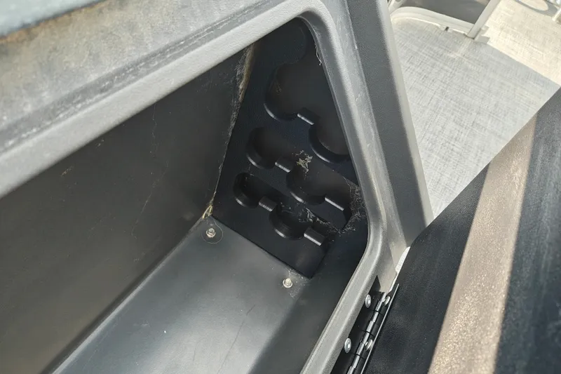 Slide: The Image of Storage compartment in 2027 Sun Tracker SportFish 22 DLX boat, featuring rod holders. - 20