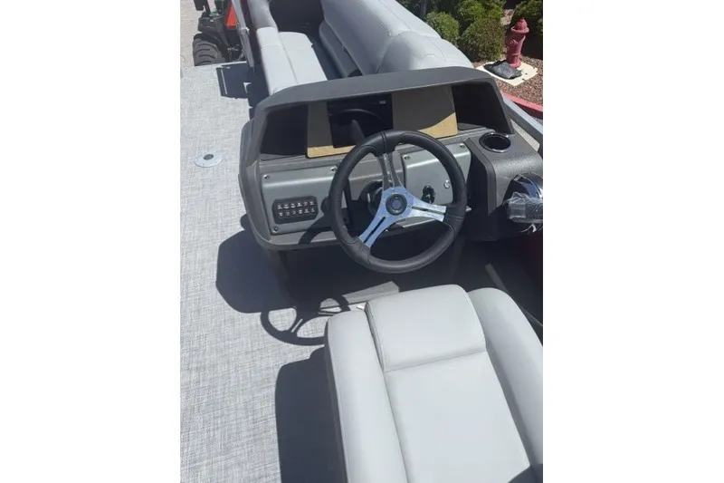 Slide: The Image of 2027 Sun Tracker SportFish 22 DLX boat interior with steering wheel and seating. - 13