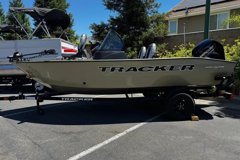 The Image of 2027 Tracker Pro Guide V-16 WT boat on trailer in parking lot. - 0