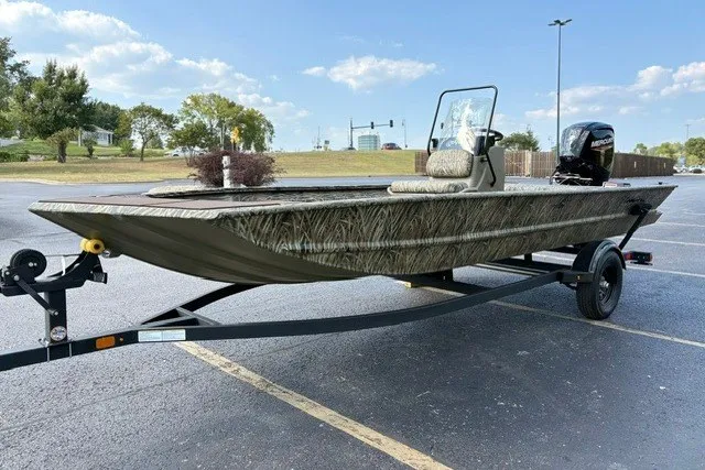 Slide: The Image of 2027 Tracker Grizzly 1860 CC boat on trailer in parking lot, camo design. - 16