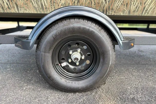 Slide: The Image of Trailer wheel of 2027 Tracker Grizzly 1860 CC on asphalt surface. - 21