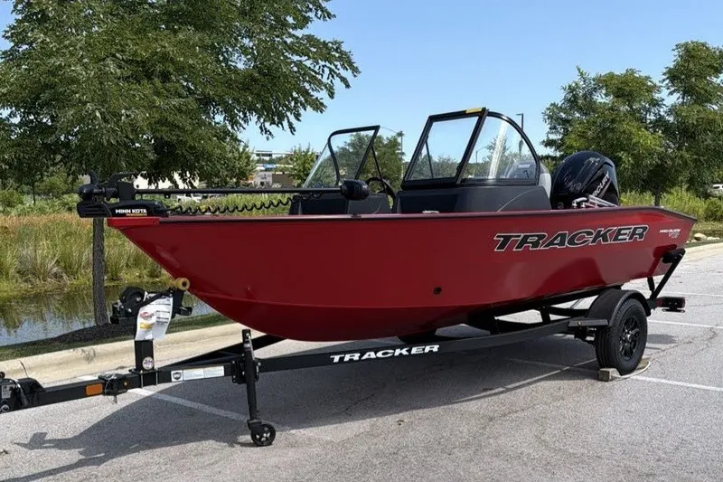 The Image of 2027 Tracker Pro Guide V-16 WT boat on trailer, parked outdoors. - 0