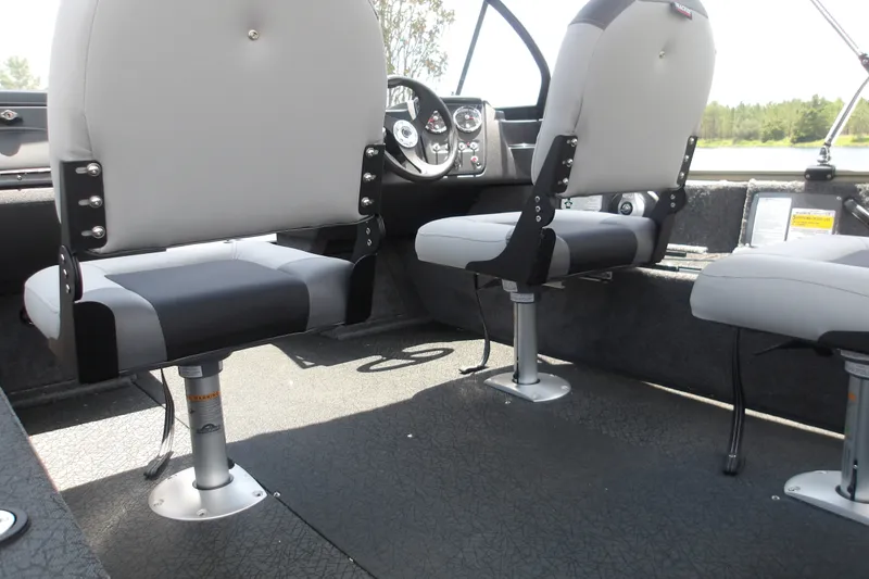 Slide: The Image of Interior of 2027 Tracker Pro Guide V-16 WT boat with gray seating and steering console. - 17