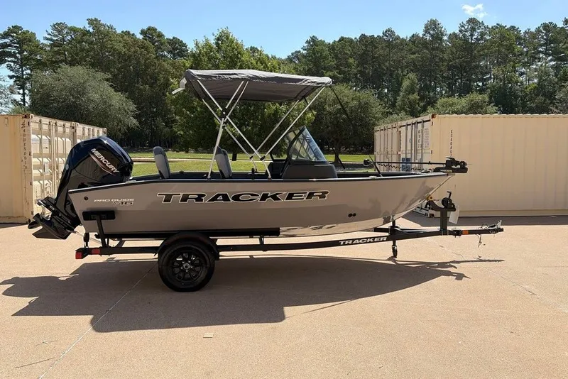 The Image of 2027 Tracker Pro Guide V-16 WT boat on trailer, parked outdoors. - 0