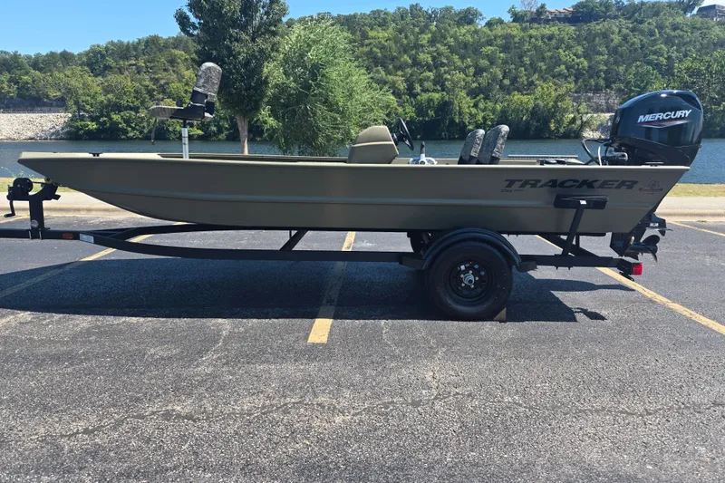 The Image of 2027 Tracker Grizzly 1754 SC boat on trailer, parked near a scenic river backdrop. - 0