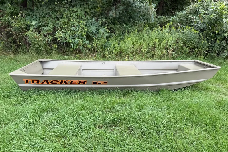 The Image of 2027 Tracker Grizzly 12 Jon boat on grass, surrounded by lush greenery. - 0
