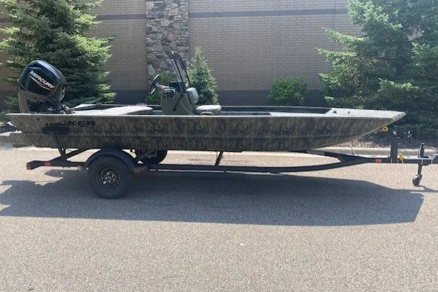 The Image of 2027 Tracker Grizzly 1860 CC boat on trailer, parked outdoors. - 0