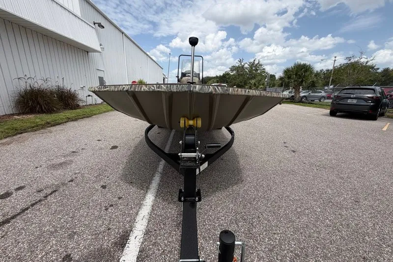 Slide: The Image of 2027 Tracker Grizzly 1860 CC boat on trailer, parked outdoors under cloudy sky. - 68