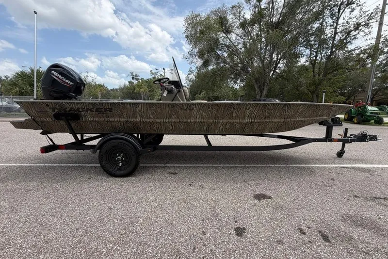 The Image of 2027 Tracker Grizzly 1860 CC boat on trailer, parked outdoors under cloudy sky. - 0