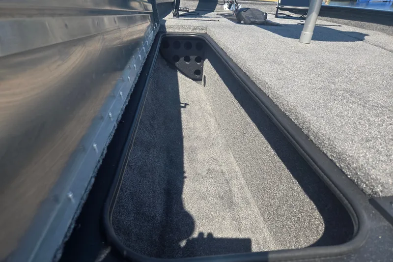 Slide: The Image of 2027 Tracker Pro Team 190 boat storage compartment with carpeted interior. - 16