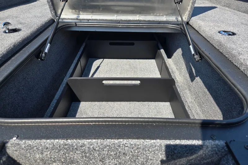 Slide: The Image of Open storage compartment of 2027 Tracker Pro Team 190 boat, featuring carpeted interior and dividers. - 17