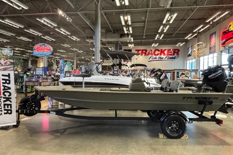 The Image of 2027 Tracker Grizzly 1754 SC boat displayed in a showroom with other marine equipment. - 0