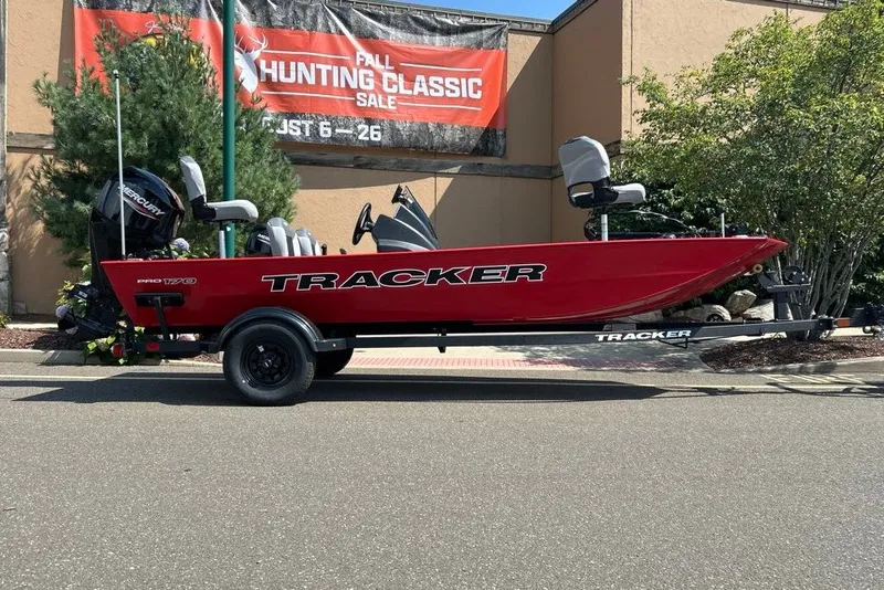 The Image of Red 2027 Tracker Pro 170 boat on trailer, displayed outdoors at a hunting sale event. - 0