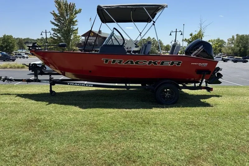 Slide: The Image of 2027 Tracker Pro Guide V-16 WT boat on trailer, parked on grass. - 14