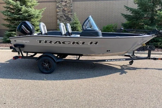 The Image of 2027 Tracker Pro Guide V-16 WT boat on trailer, parked outdoors. - 0