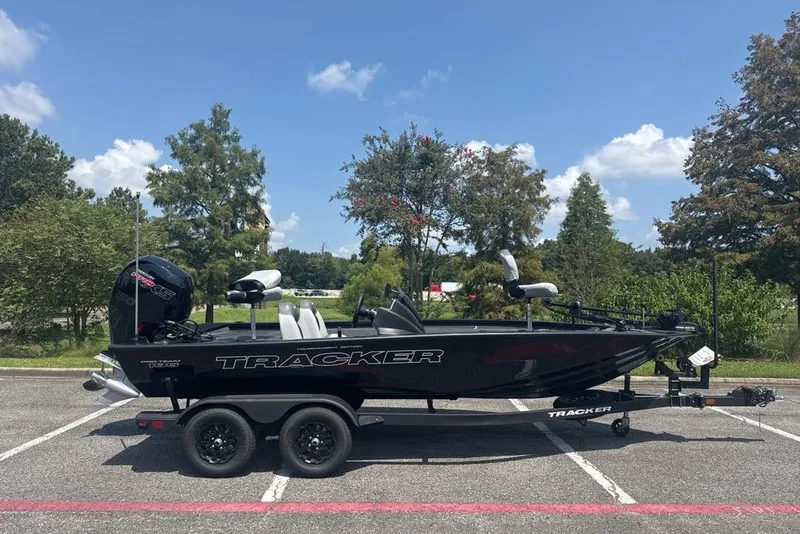 The Image of 2027 Tracker Pro Team 195 boat on trailer in sunny parking lot. - 0