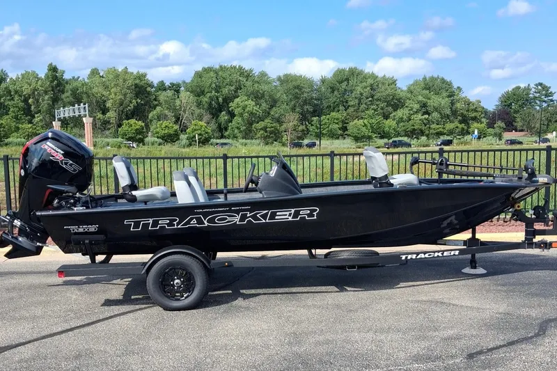 The Image of 2027 Tracker Pro Team 190 boat on trailer, parked outdoors with trees in background. - 0