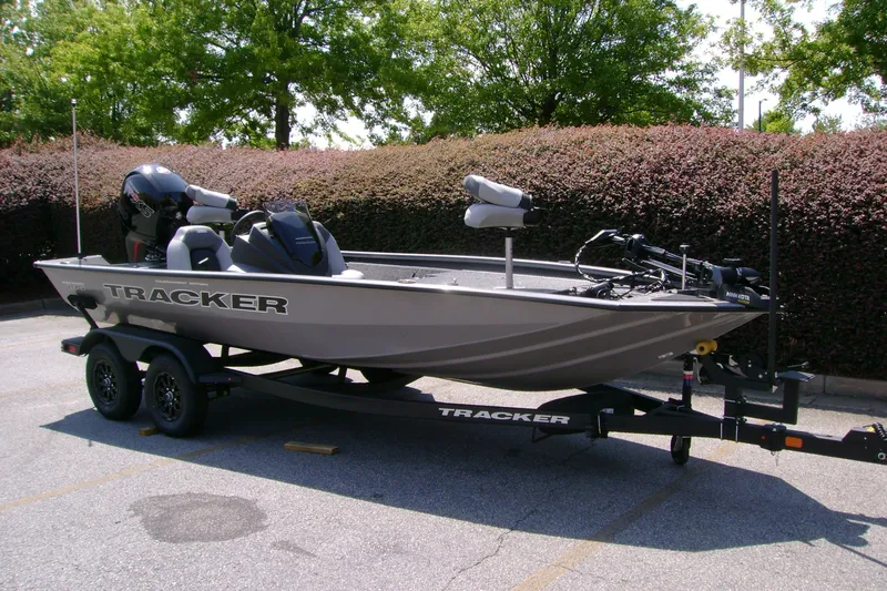 Slide: The Image of 2027 Tracker Pro Team 195 boat on trailer, parked outdoors with lush greenery background. - 38