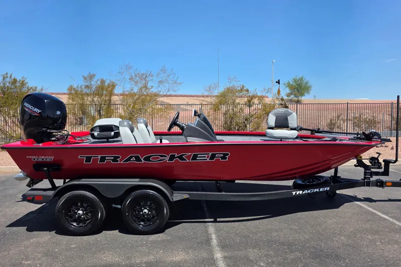 The Image of 2027 Tracker Pro Team 195 boat on trailer, red exterior, parked outdoors. - 0