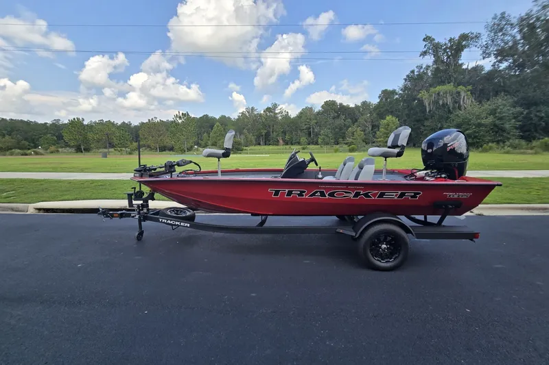 Slide: The Image of Red 2027 Tracker Pro Team 195 boat on trailer, parked outdoors under a blue sky. - 27