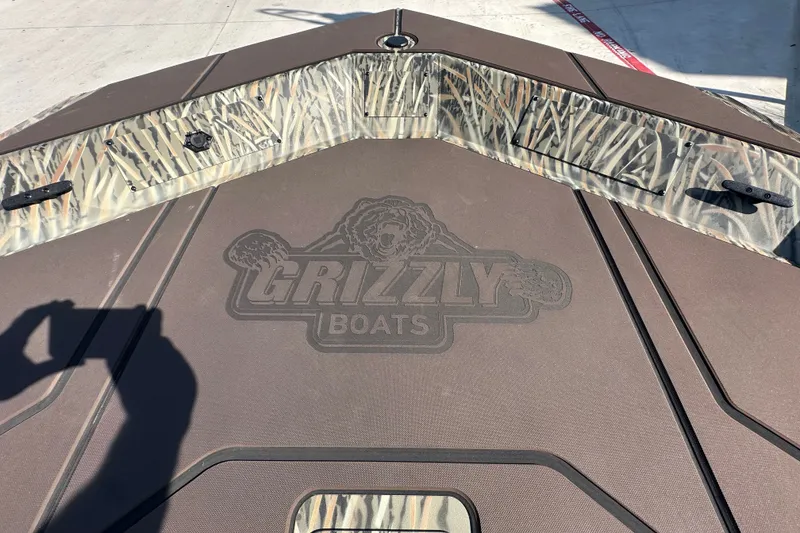 Slide: The Image of 2027 Tracker Grizzly 1860 CC boat deck with camo design and Grizzly Boats logo. - 16